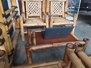 Une chaise en bambou sur laquelle est posé un ordinateur portable.
