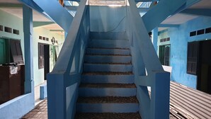 Una escalera con barandilla azul que lleva a una plataforma.