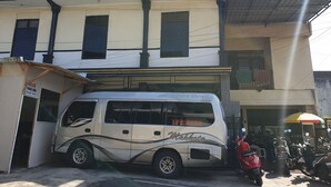 A white van parked in front of a building with a sign reading "Executive Class." - OYO Life 92622 Jatiluhur Kost Syariah (Malang)