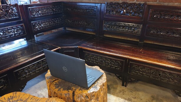 A traditional wooden furniture setting with a laptop on a carved wooden stool. - OYO Life 92622 Jatiluhur Kost Syariah (Malang)
