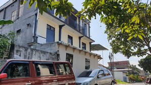 A building with a balcony and a parked car. - OYO Life 92622 Jatiluhur Kost Syariah (Malang)