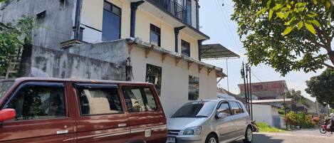 A building with a balcony and a parked car.