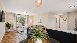 Una sala moderna con un sofá, una mesa de centro y una planta.