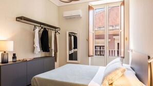 A neatly arranged bedroom with a bed, bedside table, and a mirror. - Palazzo Bozzanca by Wonderful Italy - Grey Apartment (Siracusa)