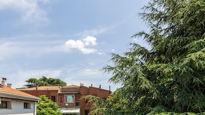 A residential area with a balcony, a metal fence, and a large tree. - Crociali Apartment by Wonderful Italy (Bologna)