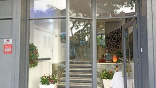 A building entrance with a glass door, a staircase leading inside, and a sign above the door. - Hostel Funchal XII (Funchal)