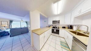 A compact kitchen with white cabinets, a microwave, a toaster, and a coffee maker. - Unbelievable View- No other unit has a view like this one. (Indialantic)