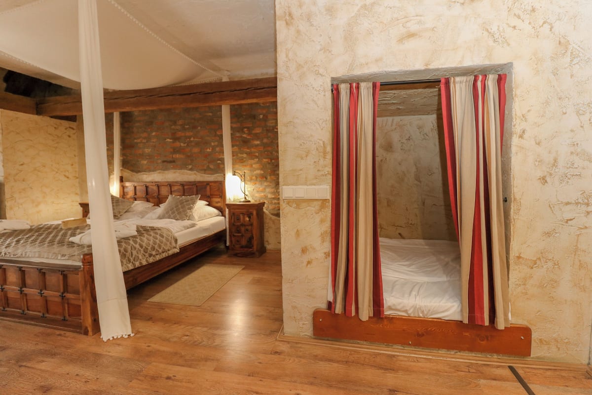 Un dormitorio con cama de madera, una mesita de noche y una pared de ladrillo.