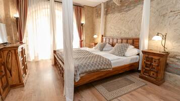 Un dormitorio con cama de madera, mesita de noche, lámpara y una alfombra decorativa.