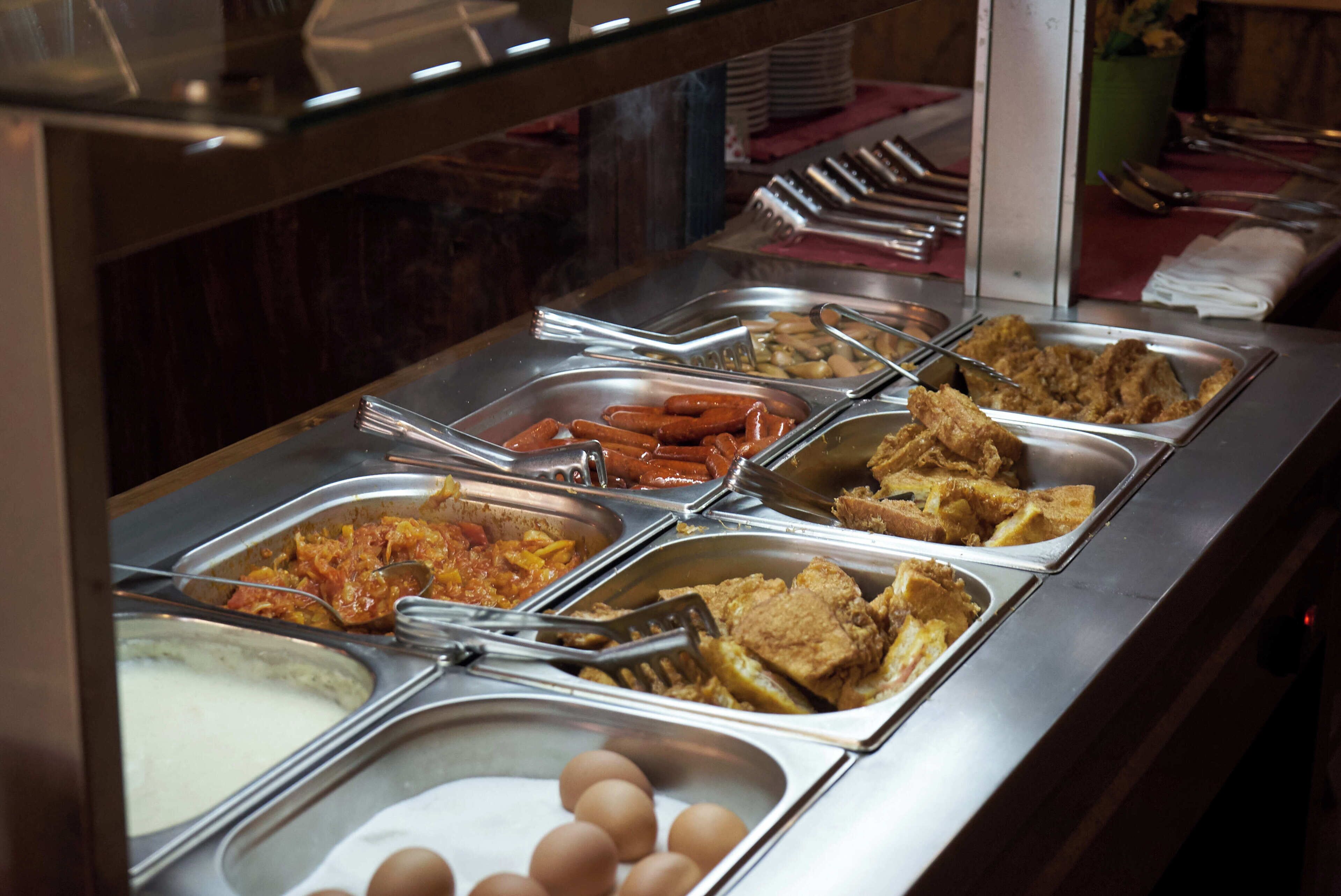 Un bufé con diversos alimentos y utensilios.