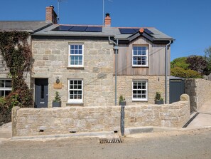 A stone cottage with a stone wall, two windows, and a door. - Stargazy Cottage (Penzance)