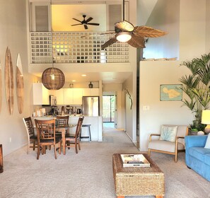 A spacious living area with a dining table, chairs, a sofa, and a coffee table.