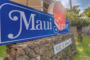 A blue sign with "Maui Sunset" and "1032 S. Kihei Rd."