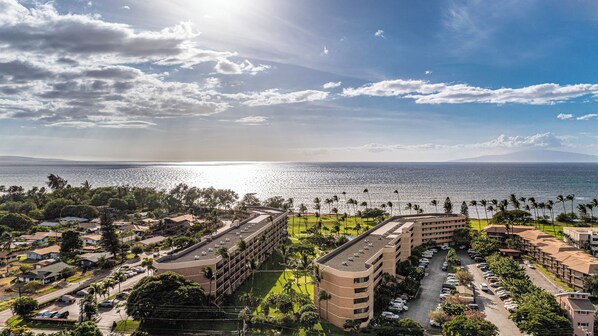 Un hotel costero con varias edificaciones, zonas de estacionamiento y vistas al océano.