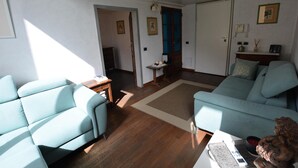 A living room with a sofa, a coffee table, and a small side table. There is a door leading to another room. - Elegant Apartment for 3 in Firenze With Elevator (Florence)