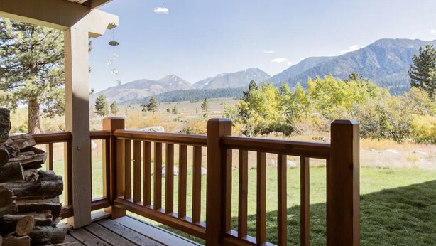 Una terraza de madera con vista a montañas.