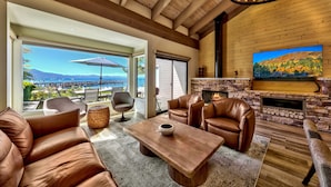 A spacious living area with leather sofas, a wooden coffee table, and a fireplace.