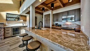 A modern kitchen with granite countertops, stainless steel appliances, and wooden accents.
