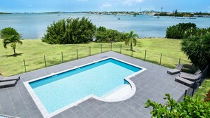 Une piscine avec vue sur la mer et les bateaux.