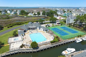 A residential area with a swimming pool, tennis courts, and a dock with boats. - The Hook: Waterfront | Boat Slip | Shared Pool (Manteo)