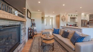A cozy living room with a fireplace, a sofa, and a coffee table. - Designer Ranch w/Gourmet Kitchen and Downtown Views. (Paso Robles)