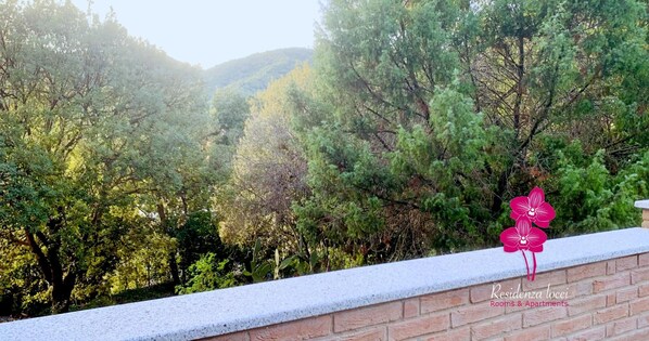 A stone wall with a view of a forested hillside. - Studio Apartment with Terrace Surrounded by Greenery in the Center of Teulada (TEULADA)