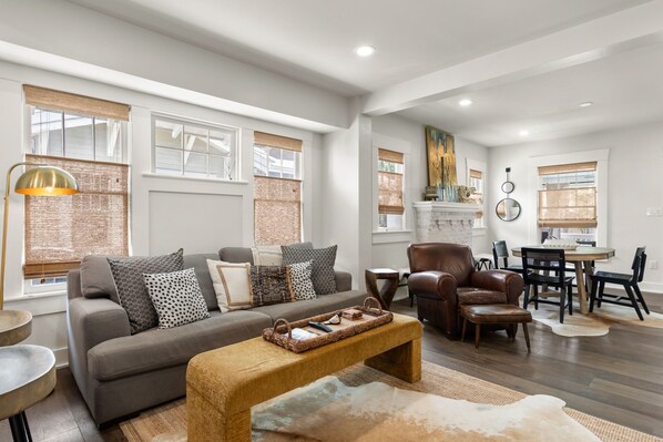 A modern living room with a sofa, coffee table, and dining area.