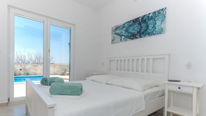 Una camera da letto con un letto, un comodino e vista su una piscina.