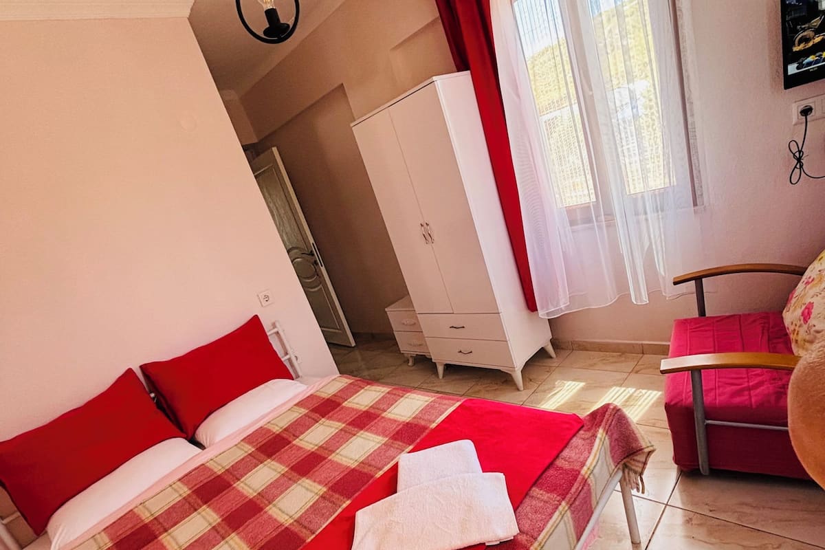 Une chambre à coucher avec un lit, une armoire, une chaise et un téléviseur.