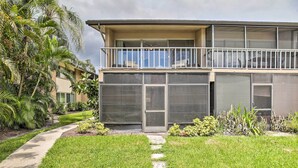 A two-story building with a balcony, large windows, and a well-maintained lawn.
