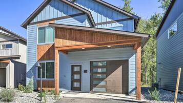 A modern two-story house with a garage, wooden accents, and a clear driveway.