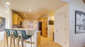 A modern kitchen with wooden cabinets, a central island, and bar stools. - Game Room + Patios: Home 2 Mi to Dtwn Flagstaff (Flagstaff)
