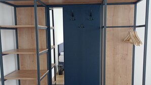 Een kleine kamer met een stapelbed, een bureau en een spiegel.
