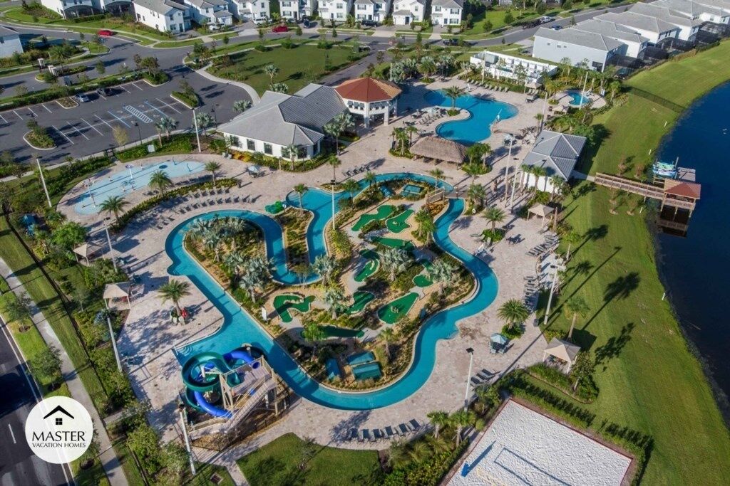 Vista aérea de un complejo turístico con varias piscinas, una piscina central grande y una zona de playa.