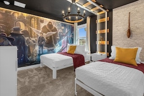 A bedroom with two beds, a mural on the wall, a wooden shelf, and a chandelier. - 9 Bedroom Champions Gate Home by RedAwning (Davenport)