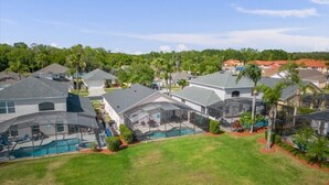 A residential area with modern houses, a swimming pool, and a well-maintained lawn.