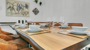 Een eetgedeelte met een houten tafel voor vier personen, omringd door lederen stoelen.