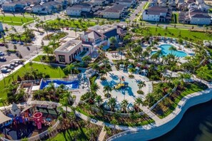 Vue aérienne d’un complexe hôtelier doté de plusieurs piscines, de palmiers et d’une aire de jeux.