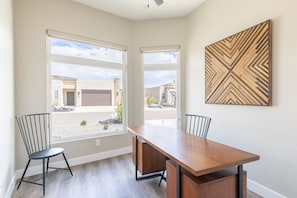 Enjoy meals at the large dining table, flanked by two chairs, with a view of the surrounding neighborhood.