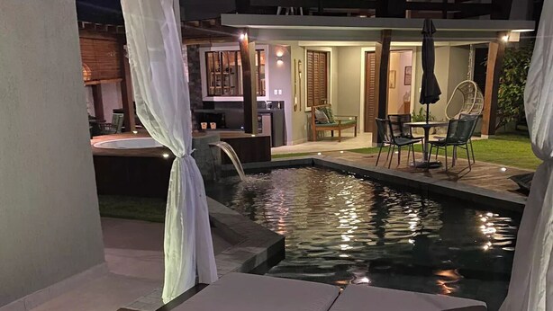 A poolside area with lounge chairs and a small pool. - CASA BALI - Charm and comfort in Guarajuba  (Guarajuba)