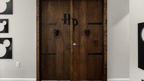 A wooden double door with a 'Hp' symbol, two black door handles, and a keyhole. - 9 Bed Storey Lake Star Wars Dream Home 9 Bedroom Home by RedAwning (Kissimmee)