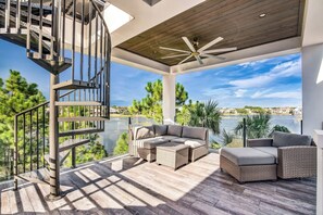 Eine moderne Außenpatio mit einem Korbsessel, einem kleinen Tisch und einer Wendeltreppe.