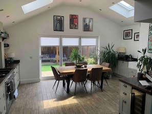 Enjoy meals in the spacious dining area with an oven and stove, surrounded by natural light and lush greenery.