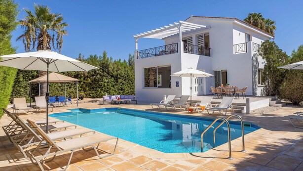 Ein modernes, zweistöckiges Haus mit Swimmingpool, Gartenmöbeln und einer Pergola.
