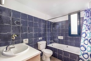 Een bad/douchecombinatie, handdoeken