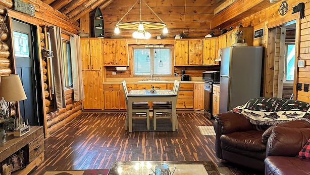 L’intérieur d’une cabane en rondins comprend un coin repas, une cuisine et un salon.