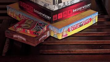 A stack of board games on a wooden surface.