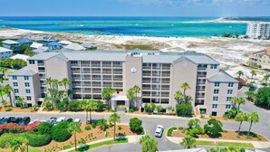 A hotel with multiple floors, a parking lot, and a view of the beach and ocean. - 1BR Coastal Condo + 3 Pools & Private Beach Access | Magnolia House 107 (Destin)