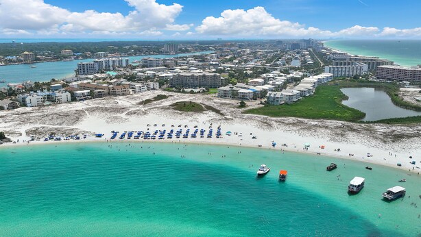 A coastal cityscape with a beach, clear turquoise waters, and a mix of residential and commercial buildings. - 1BR Coastal Condo + 3 Pools & Private Beach Access | Magnolia House 107 (Destin)