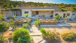 Un bâtiment rustique en pierre, doté d’une terrasse et d’un jardin.